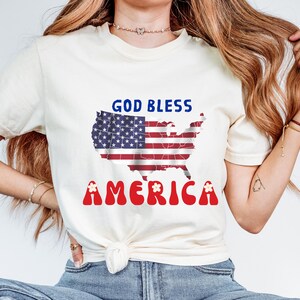 Que Dieu bénisse l'Amérique | graphique de drapeau de carte des Etats-Unis | T-shirt marguerite rétro du 4 juillet | T-shirt vintage patriotique Comfort Colors