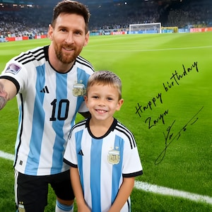 Peut inclure: Un homme et un jeune garçon portant des maillots de football argentins assortis à rayures bleues et blanches, debout sur un terrain vert. Le maillot de l'homme porte le numéro 10. L'image comprend le texte "Happy birthday Zayn" et une signature.