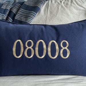 May include: A navy blue pillow with the number 08008 embroidered in gold thread.