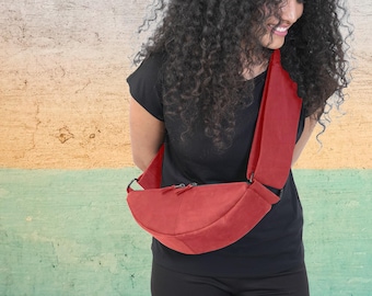 Bolso bandolera de media luna de piel roja: compartimentos amplios y correa ajustable.