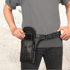 Puede incluir: Bolso cintur&oacute;n de cuero negro con cierre de solapa y bolsillo con cremallera. El bolso est&aacute; sujeto a un cintur&oacute;n de cuero negro con hebilla plateada. El bolso cintur&oacute;n est&aacute; dise&ntilde;ado para llevarse alrededor de la cintura.