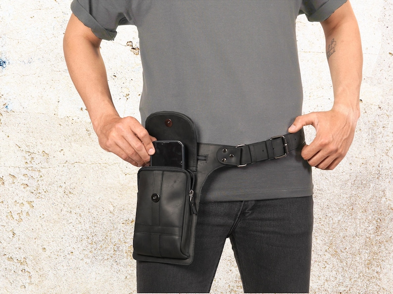 Puede incluir: Bolso cintur&oacute;n de cuero negro con cierre de solapa y bolsillo con cremallera. El bolso est&aacute; sujeto a un cintur&oacute;n de cuero negro con hebilla plateada. El bolso cintur&oacute;n est&aacute; dise&ntilde;ado para llevarse alrededor de la cintura.