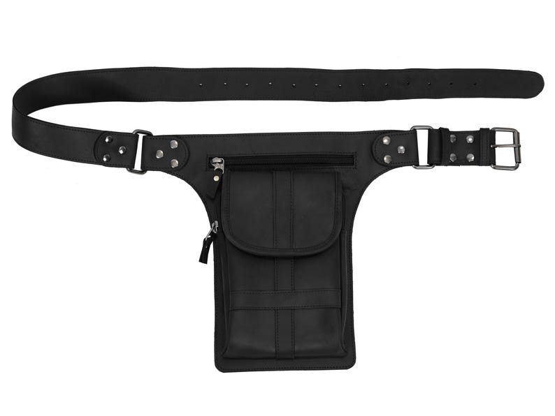 Puede incluir: Ri&ntilde;onera de cuero negro con cintur&oacute;n. La ri&ntilde;onera tiene un bolsillo rectangular con solapa, un bolsillo con cremallera y un cintur&oacute;n con hebilla. El cintur&oacute;n tiene varios agujeros para ajustar y est&aacute; asegurado con remaches.