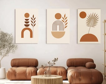 May include: Three abstract art prints with geometric shapes and botanical elements in shades of brown and beige. The artwork features arches, circles, and leaf-like designs, creating a modern and minimalist aesthetic. The prints are displayed above brown leather furniture.