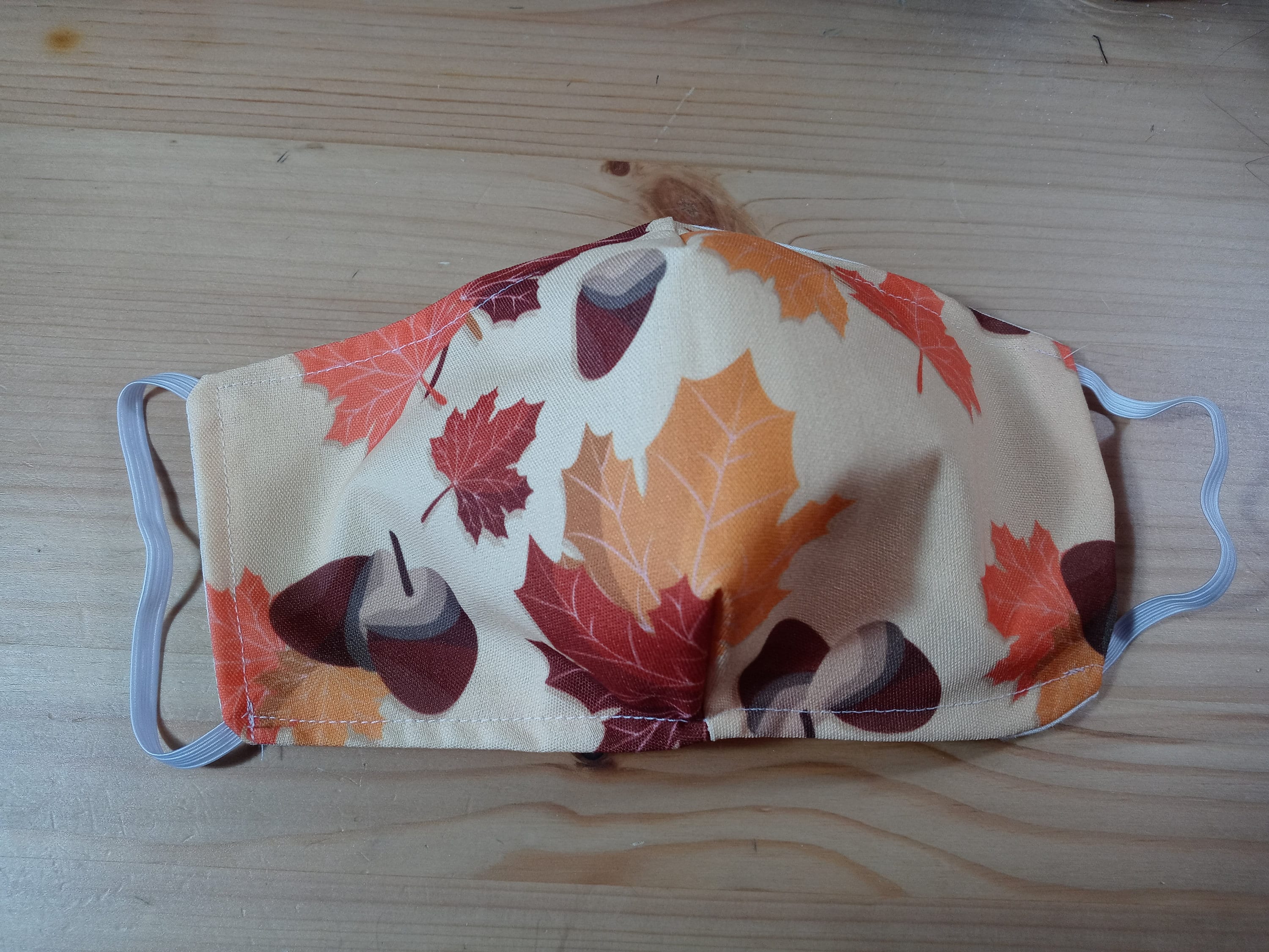 Fall Face Mask with Side Opening for Filters.  This Autumn Leaves with Acorns Face Covering Includes 5 PM 2.5 filters. Orange, Beige, Brown