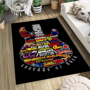 Puede incluir: Una alfombra rectangular negra que presenta un gran gráfico con forma de guitarra compuesto por varios nombres de bandas en tipografía colorida. El texto incluye nombres como Metallica, AC/DC, Kiss y Pink Floyd, con las palabras Legends of Rock abajo.