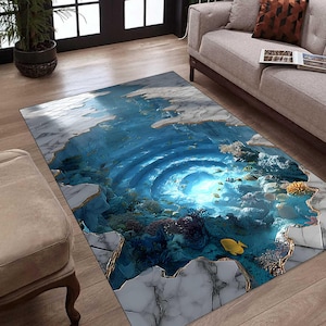 Könnte beinhalten: Rechteckiger Teppich mit 3D-Ozean-Design. Der Teppich hat ein blau-weißes Farbschema mit einem Wirbel im Zentrum, umgeben von Korallen und Fischen. Die Ränder haben ein marmorähnliches Aussehen.