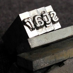 Ser una estrella. La impresión tipográfica antigua bloquea la ortografía de palabras. Suministros para impresoras retro o fabricación de joyas y hallazgos divertidos en técnicas mixtas.
