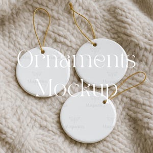 May include: Three white, round ceramic ornaments with gold hanging strings are arranged on a textured, off-white surface. The word "Ornaments" and "Mockup" are printed on the ornaments.