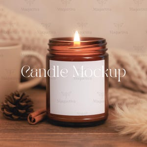 May include: A lit brown glass candle jar with a white label, the text "Candle Mockup" is on the label. A pine cone and cinnamon stick are next to the candle. The candle is on a wooden surface.