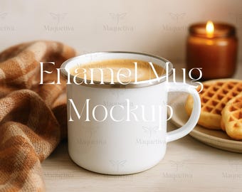 May include: A white enamel mug filled with coffee, with the text "Enamel Mug Mockup". A lit candle and waffles are in the background. A brown and orange plaid blanket is draped on the left.