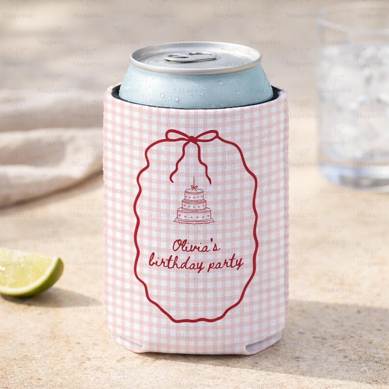 May include: A pink and white gingham can cooler with a red outline of a cake and the text "Olivia's birthday party." The cooler is holding a light blue can. A slice of lime is in the lower left corner.