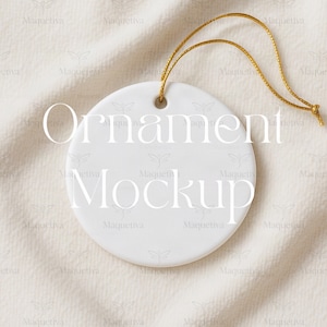 May include: A white, circular ornament mockup with a gold hanging string. The words "Ornament" and "Mockup" are printed on the ornament. The background is a textured, off-white fabric.