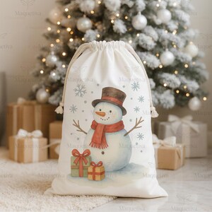 Peut inclure: Un sac cadeau blanc &agrave; cordon de serrage avec un bonhomme de neige &agrave; l'aquarelle portant un chapeau haut de forme marron et une &eacute;charpe rouge. Le bonhomme de neige est entour&eacute; de flocons de neige et de deux cadeaux emball&eacute;s. Arri&egrave;re-plan avec un sapin de No&euml;l et des cadeaux.