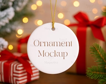 May include: A white, round Christmas ornament mockup with the text "Ornament Mockup" in brown. The ornament hangs from a gold string. Presents with red bows and Christmas tree branches are in the background.