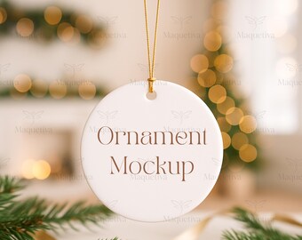 Könnte beinhalten: Ein weißer, runder Ornament mit dem Text "Ornament Mockup" in Braun. Das Ornament hängt an einem goldenen Faden. Der Hintergrund zeigt verschwommene Weihnachtsbeleuchtung und Tannenzweige.
