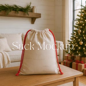 May include: A beige drawstring sack with red cords and tassels, sitting on a wooden table. The text "Sack Mockup" is printed on the front of the sack. The background includes a couch, Christmas tree, and wrapped gifts.