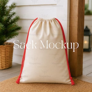 May include: A cream-colored drawstring sack with red rope handles and tassels. The text "Sack Mockup" is printed on the front. The sack is set against a white wall and a wooden post, with a small Christmas tree in a basket on the left.