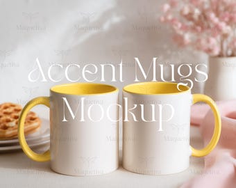 May include: Two white ceramic mugs with yellow interiors and handles. The mugs are side-by-side, with the text "Accent Mugs Mockup" overlaid on the image. A plate with a waffle is visible in the background.