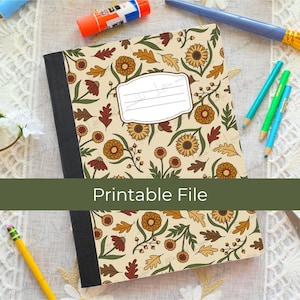 Puede incluir: Un cuaderno con lomo negro y portada color crema que presenta un patrón repetitivo de flores y hojas en tonos marrón, naranja y amarillo. Una etiqueta rectangular blanca con tres líneas horizontales está centrada en la portada.