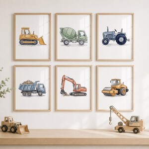 May include: A set of six framed wall art prints featuring watercolor illustrations of construction vehicles including a yellow bulldozer, green cement mixer, blue tractor, blue dump truck, orange excavator, and yellow road roller on white backgrounds.