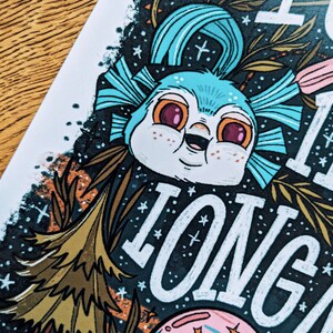 Może przedstawiać: Fantazyjna ilustracja niebieskiego stworzenia z dużymi oczami i szerokim uśmiechem, otoczonego gwiazdami i kwiatami. Tekst "It's a long way to the top" jest napisany białymi literami.