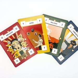 May include: Four colorful game cards with art deco designs. The cards are labeled "Meme Stocks", "Crypto", "Real Estate", and "Commodities". Each card features unique illustrations and numerical values, with a white background.