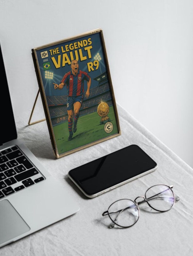 K&ouml;nnte beinhalten: Ein gerahmtes Comic-Cover mit einem Fu&szlig;ballspieler in einem rot-blauen Trikot mit dem Text "The Legends Vault R9" auf dem Cover.
