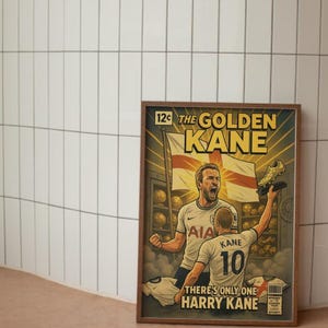 Puede incluir: Una impresi&oacute;n enmarcada de estilo c&oacute;mic con un jugador de f&uacute;tbol, con el texto "THE GOLDEN KANE". El jugador est&aacute; representado con una camiseta blanca, sosteniendo una bota dorada. La impresi&oacute;n incluye el texto "THERE'S ONLY ONE HARRY KANE."