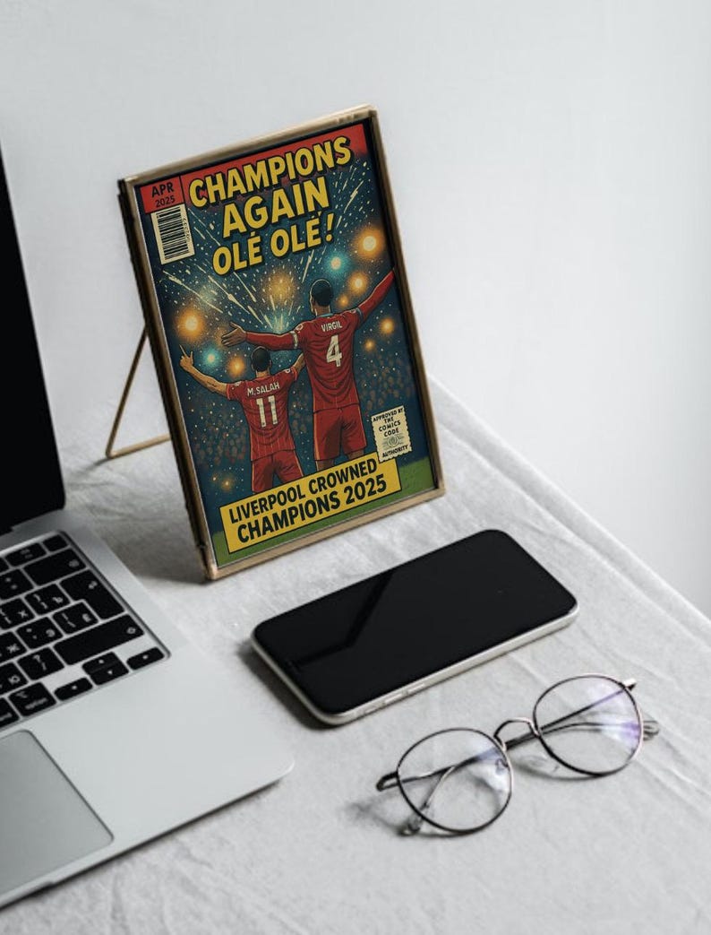 May include: A comic book cover with a gold frame featuring two soccer players celebrating a victory. The cover reads "Champions Again Ole Ole!" and "Liverpool Crowned Champions 2025".