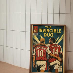 Peut inclure: Une affiche encadr&eacute;e de style bande dessin&eacute;e repr&eacute;sentant deux joueurs de football en maillots rouges avec les num&eacute;ros 10 et 14. Le texte dit "THE INVINCIBLE DUO" dans un style de bande dessin&eacute;e vintage.