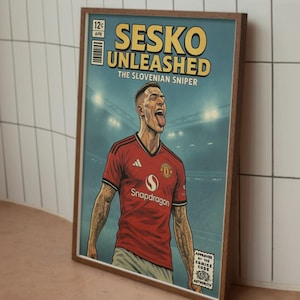 May include: A framed comic book style print featuring a soccer player in a red jersey with the text "SESKO UNLEASHED". The player is sticking out their tongue. The print has a vintage comic book aesthetic.
