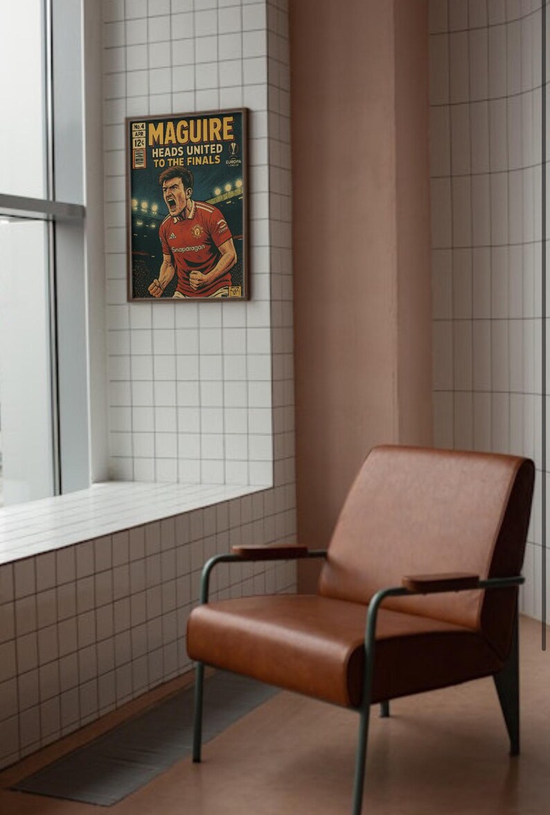 May include: A vintage-style comic book cover featuring a soccer player in a red jersey with the text "MAGUIRE HEADS UNITED TO THE FINALS" printed on the cover. The comic book cover is framed and hanging on a wall.