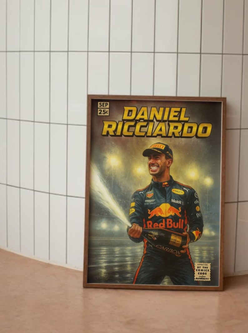Puede incluir: Un p&oacute;ster enmarcado con Daniel Ricciardo, un piloto de F&oacute;rmula 1, celebrando con champ&aacute;n. El p&oacute;ster tiene un estilo de c&oacute;mic vintage con el texto "DANIEL RICCIARDO" en amarillo. El logotipo de Red Bull es visible.