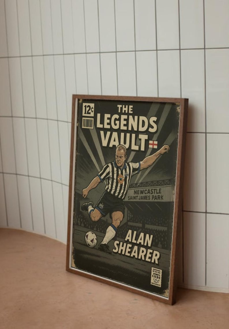 May include: A framed vintage-style print featuring a soccer player kicking a ball. The print reads "The Legends Vault" and "Alan Shearer" with the Newcastle Saint James Park stadium in the background. The color palette includes black, white, and brown.