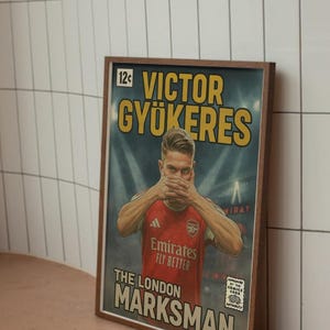 May include: Framed comic book style poster featuring Victor Gyokeres in an Arsenal jersey. The poster has a vintage aesthetic with text that reads "VICTOR GYOKERES" and "THE LONDON MARKSMAN". The Emirates Fly Better logo is also visible.