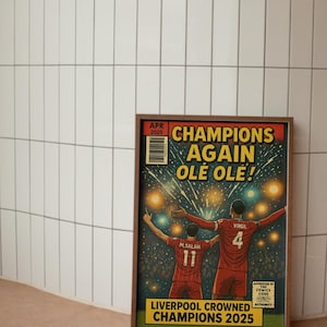 May include: A comic book cover featuring two soccer players celebrating a victory. The cover is titled "Champions Again Ole Ole!" and features the text "Liverpool Crowned Champions 2025".