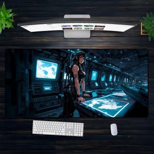 Könnte beinhalten: Große rechteckige Schreibtischunterlage mit einer futuristischen Anime-Illustration einer Frau in schwarzer Kleidung in einem Raumschiff-Kontrollraum. Die Matte hat ein dunkelblaues und schwarzes Farbschema mit neonblauen Akzenten. Eine weiße Tastatur und Maus sind sichtbar.