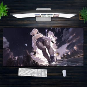May include: A large rectangular desk mat with an anime-style illustration of a woman in a fantasy landscape. The design includes a starry night sky, mountains, and a figure in shorts and boots. A white keyboard and mouse are also visible.