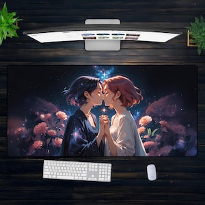 Könnte beinhalten: Ein großes rechteckiges Mauspads mit einer Illustration von zwei sich küssenden Frauen, umgeben von Blumen und einem Sternenhimmel. Eine weiße Tastatur und Maus sind darunter zu sehen.