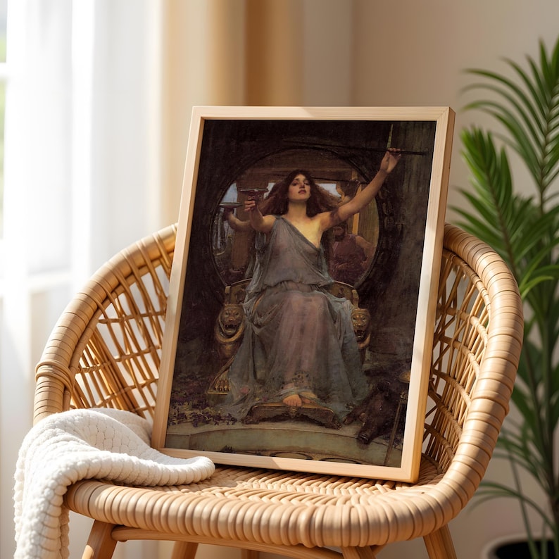 May include: A framed print of a classical painting depicting a woman in a flowing gown seated on a throne. The artwork features muted tones of blue, brown, and gold, with the woman holding a chalice and a wand. The frame is made of light-colored wood.