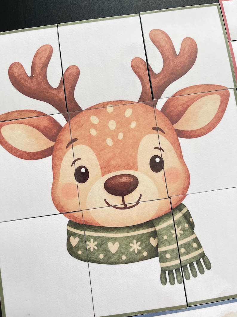 Pu&ograve; includere: Un puzzle quadrato composto da nove tessere individuali raffigurante la testa di un cervo in stile cartoon con corna marroni, grandi occhi scuri e un muso marrone chiaro. Il cervo indossa una sciarpa verde decorata con cuori, stelle e puntini bianchi.