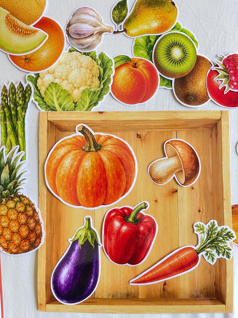 May include: A collection of die-cut stickers featuring various fruits and vegetables, including a pumpkin, eggplant, red bell pepper, carrot, mushroom, pineapple, asparagus, cauliflower, garlic, pear, kiwi, peach, orange, melon, and raspberry.