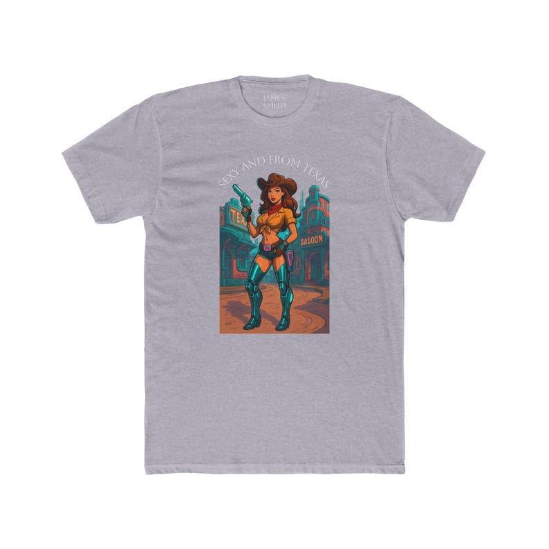May include: A heather gray t-shirt featuring a cartoon illustration of a cowgirl holding a gun. The cowgirl is wearing a yellow top, blue shorts, and boots. Text on the shirt reads "Sexy and From Texas."