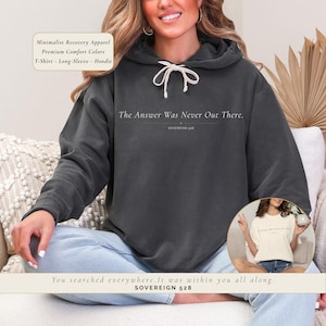 May include: Dark gray hoodie with the text "The Answer Was Never Out There." and "SOVEREIGN 528." The image also includes a smaller image of a white t-shirt with the same text. The text "You searched everywhere. It was within you all along." is also visible.