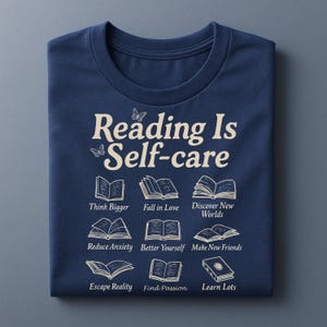 Puede incluir: Camiseta azul marino con el texto "Reading Is Self-care" e ilustraciones de libros. La camiseta tambi&eacute;n incluye las frases "Think Bigger", "Fall in Love", "Discover New Worlds", "Reduce Anxiety", "Better Yourself", "Make New Friends", "Escape Reality", "Find Passion" y "Learn Lots".