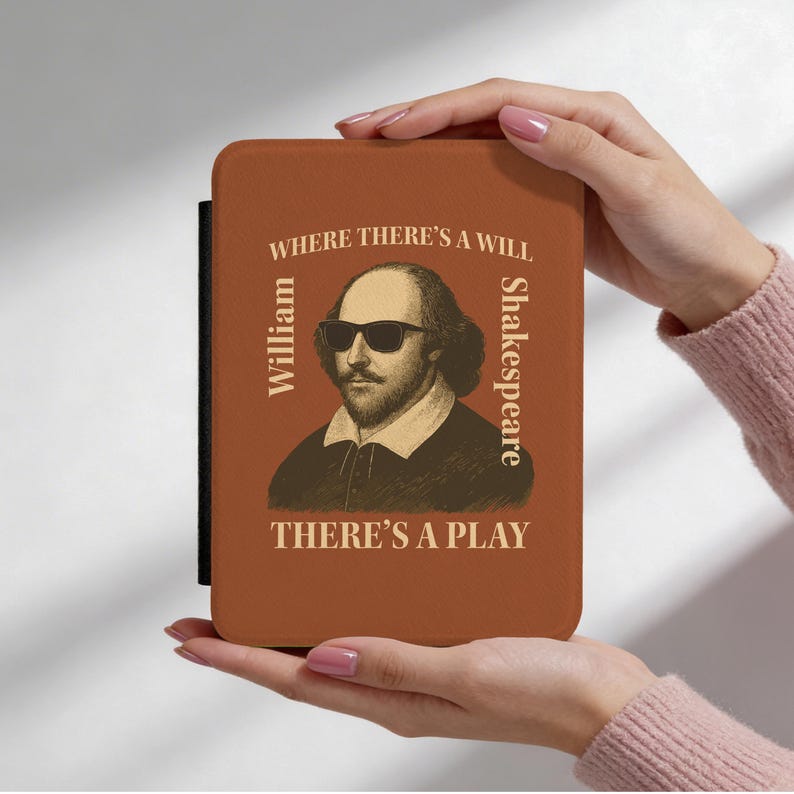May include: A brown case featuring a portrait of William Shakespeare wearing sunglasses. The text reads "Where there's a will, there's a play." The case has a black spine. A literary-themed accessory.