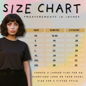 Puede incluir: Una tabla de tallas con medidas en pulgadas para camisetas. La tabla enumera las tallas XS a 3XL con las medidas de ancho y largo correspondientes. El texto anima a elegir una talla m&aacute;s grande para un look oversize o la talla habitual para un estilo ajustado.