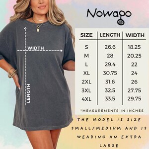 May include: A dark grey t-shirt with a size chart and the brand name "Nowago". The chart lists measurements in inches for sizes S to 4XL. The model is wearing an extra large.