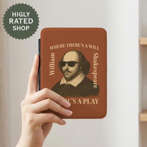 May include: A brown case featuring a portrait of William Shakespeare wearing sunglasses, with the text "WHERE THERE'S A WILL THERE'S A PLAY." The case is held by a hand. The case is for an e-reader or tablet.